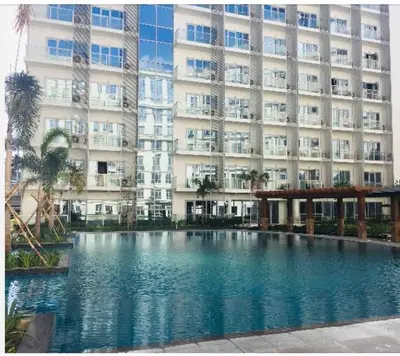 a swimming pool in front of a large building at Studio Room Walking Airport, In City Of Newport City in Manila