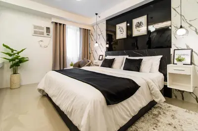a bedroom with a large bed with a black headboard at Luxury condo At Shore 1 Tower C1, Mall of Asia Complex Pasay City in Manila
