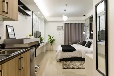 a bedroom with a bed and a kitchen with a sink at Luxury condo At Shore 1 Tower C1, Mall of Asia Complex Pasay City in Manila
