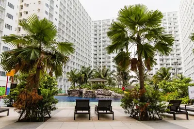 a hotel courtyard with palm trees and a swimming pool at Luxury condo At Shore 1 Tower C1, Mall of Asia Complex Pasay City in Manila