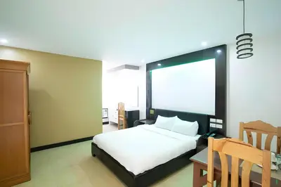 a bedroom with a white bed and a table and a chair at OYO 195 Ranchotel - Biñan in Biñan
