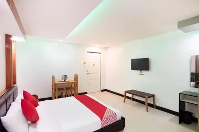 a bedroom with a bed and a tv on the wall at OYO 195 Ranchotel - Biñan in Biñan