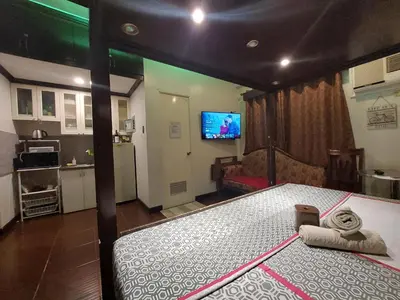 a bedroom with a bed and a tv in it at NAIA Airport Fasanvej Studio condo NetflixTv 4pax in Manila