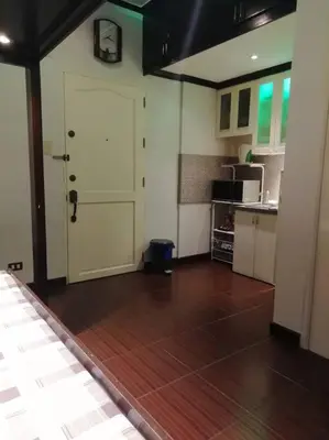 a living room with a white door and a kitchen at NAIA Airport Fasanvej Studio condo NetflixTv 4pax in Manila
