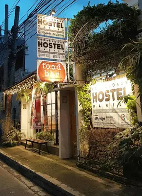 a building with signs on the side of a street at Crossroads Hostel Manila in Manila