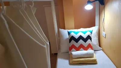 a room with a bed with a pillow on it at Crossroads Hostel Manila in Manila