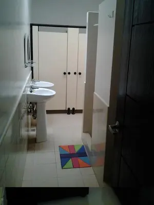 a bathroom with a sink and a toilet and a rainbow floor at Crossroads Hostel Manila in Manila