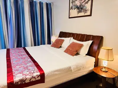 a bed in a bedroom with blue curtains at ONE UPTOWN \uff08BGC\uff09 in Manila
