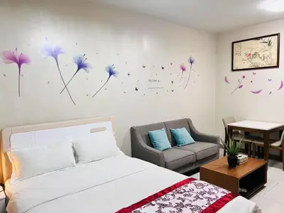 a bedroom with a bed and a chair and flowers on the wall at ONE UPTOWN \uff08BGC\uff09 in Manila