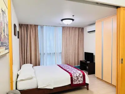a hotel room with a bed and a window at ONE UPTOWN \uff08BGC\uff09 in Manila