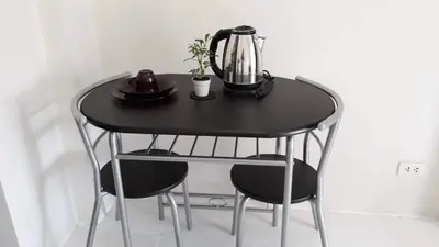 a black table with two chairs and a tea kettle on it at Cozy Studio @ One Capitol Condo 2nd St. Kapitolyo in Manila