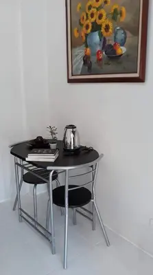 a table with two chairs and a painting on the wall at Cozy Studio @ One Capitol Condo 2nd St. Kapitolyo in Manila