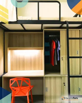 a bunk bed with a red chair in a room at The City Flats Amorsolo in Manila