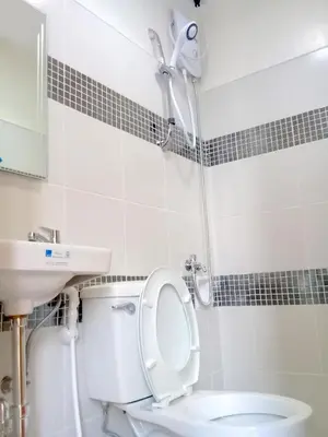 a bathroom with a shower and a toilet and a sink at Airport Poddotel Inc. in Manila