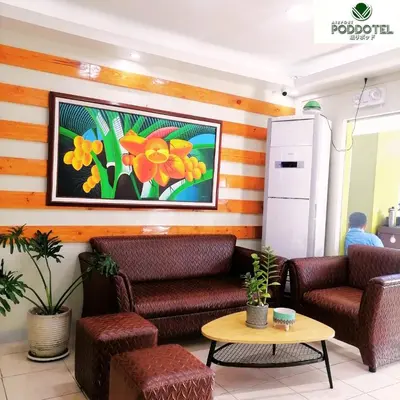 a lobby with two chairs and a painting on the wall at Airport Poddotel Inc. in Manila