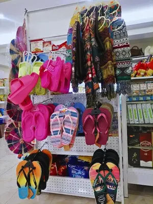 a store shelf filled with lots of shoes and umbrellas at Airport Poddotel Inc. in Manila
