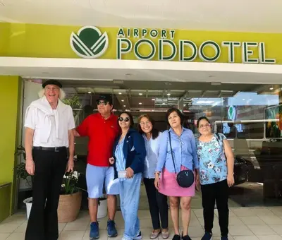 a group of people standing in front of an airport robbed at Airport Poddotel Inc. in Manila