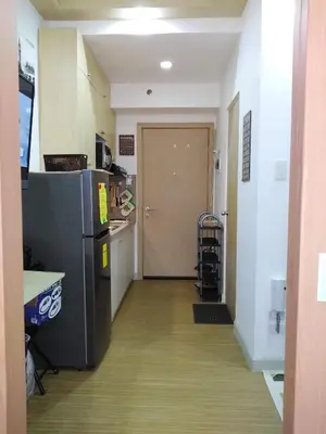 a hallway of a kitchen with a refrigerator and a door at SMDC GRACE RESIDENCIES in Manila