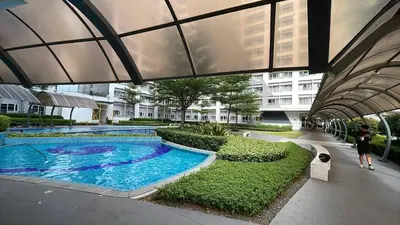 a woman walking past a swimming pool in a building at SMDC GRACE RESIDENCIES in Manila