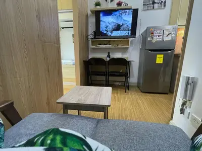 a living room with a couch and a television and a table at SMDC GRACE RESIDENCIES in Manila