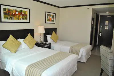 a hotel room with two beds and a lamp at Tower Inn Makati Business Hotel in Manila