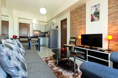 a living room with a blue couch and a tv at The Beacon 1BR for 4, T2, WIFI 300Mbps in Manila