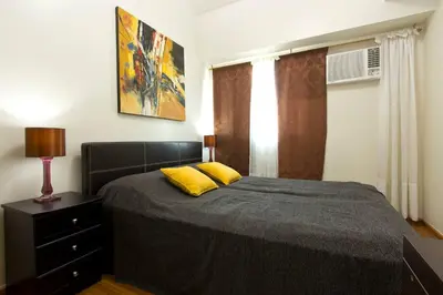 a bedroom with a bed with two yellow pillows at The Beacon 1BR for 4, T2, WIFI 300Mbps in Manila