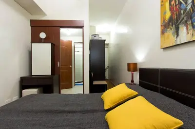 a bedroom with a bed with a yellow pillow on it at The Beacon 1BR for 4, T2, WIFI 300Mbps in Manila