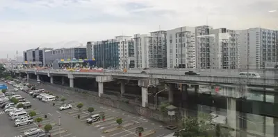 a bridge over a parking lot with cars and buildings at SIBARIAN Condo unit C1 10th Floor in Manila