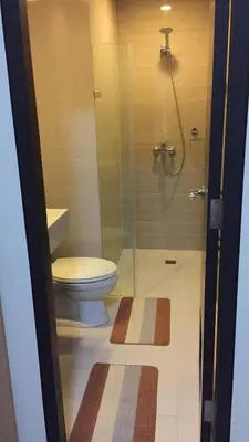 a bathroom with a toilet and a glass shower at SIBARIAN Condo unit C1 10th Floor in Manila
