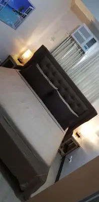 a large bed in a room with a light at SIBARIAN Condo unit C1 10th Floor in Manila