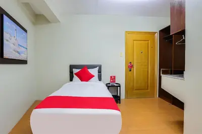 a bedroom with a red and white bed and a yellow door at Anglo Residences Manila in Manila