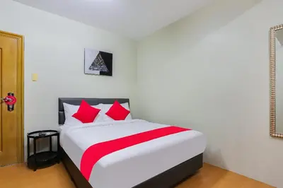 a bedroom with a large bed with red pillows at Anglo Residences Manila in Manila