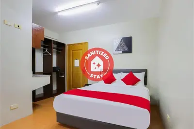 a bedroom with a bed with a red sign on it at Anglo Residences Manila in Manila