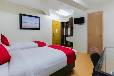 a hotel room with two beds and a television at Anglo Residences Manila in Manila