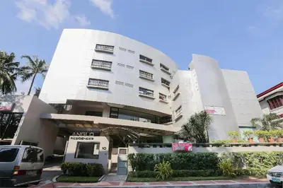 a white building with a van parked in front of it at Anglo Residences Manila in Manila