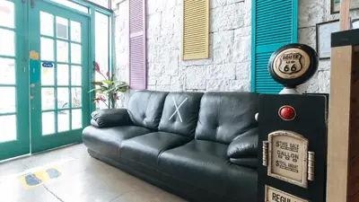 a black leather couch sitting in a room at RedDoorz Plus at BGC near St Lukes in Manila