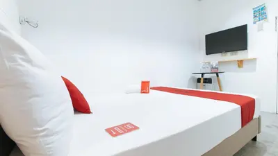 a white bed in a room with a tv at RedDoorz Plus at BGC near St Lukes in Manila