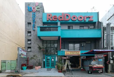 a building with a red door and a sign on it at RedDoorz Plus at BGC near St Lukes in Manila