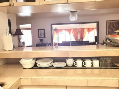 a kitchen with a shelf filled with white dishes at Casa Meyer's BF Homes International House for rent with pool and Jacuzzi in Manila