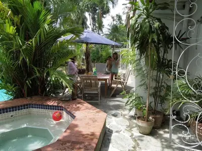 a hot tub in a garden with people sitting at a table at Casa Meyer's BF Homes International House for rent with pool and Jacuzzi in Manila