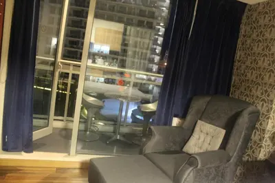 a living room with a chair and a window at AZURE C4 BEACHPOOL balcony wifi MULTIPLE UNITS in Manila