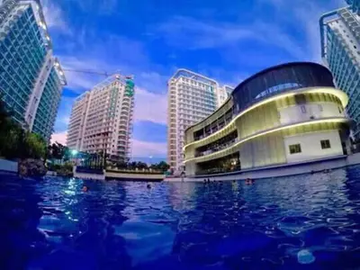 a building with a pool of water in front of buildings at AZURE C4 BEACHPOOL balcony wifi MULTIPLE UNITS in Manila