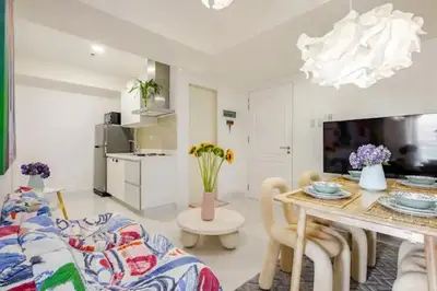 a living room with a table and a kitchen at Sabrina'sCrib Apartment 2BR by Azure Residences Near Manila International Airport in Manila
