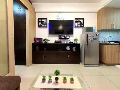 a living room with a refrigerator and a table with plants at Condominium Shore 1 Mall of Asia in Manila