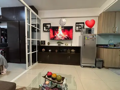 a living room with a kitchen with a tv on the wall at Condominium Shore 1 Mall of Asia in Manila