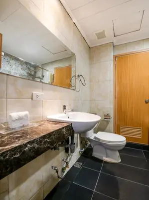 a bathroom with a sink and a toilet at Bay Area Suites Manila in Manila