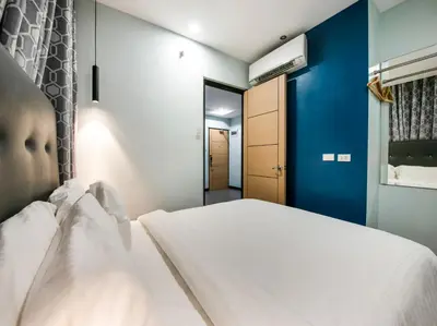 a bedroom with a white bed and a blue wall at Bay Area Suites Manila in Manila