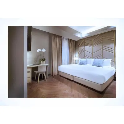 a bedroom with a large white bed and a desk at Summit Hotel Greenhills in Manila