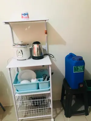 a white shelf with dishes and a tea pot on it at Shanilyn Residency Urban Deca Towers EDSA mandaluyong Unlimited INTERNET AND NETFLIX in Manila